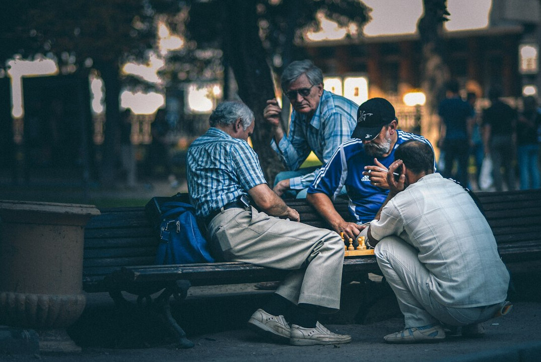 elderly people playing cards in park